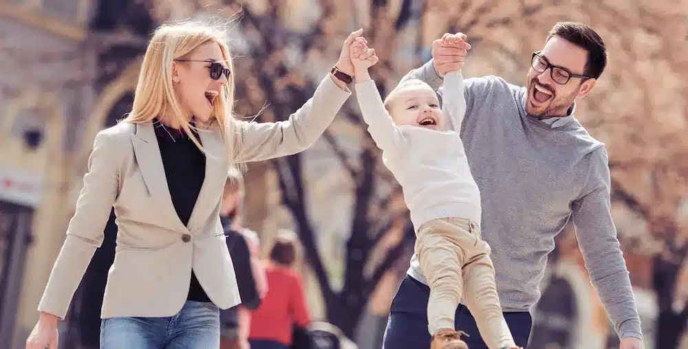 Happy family with little child and shopping bags in city Adobestock 199023815