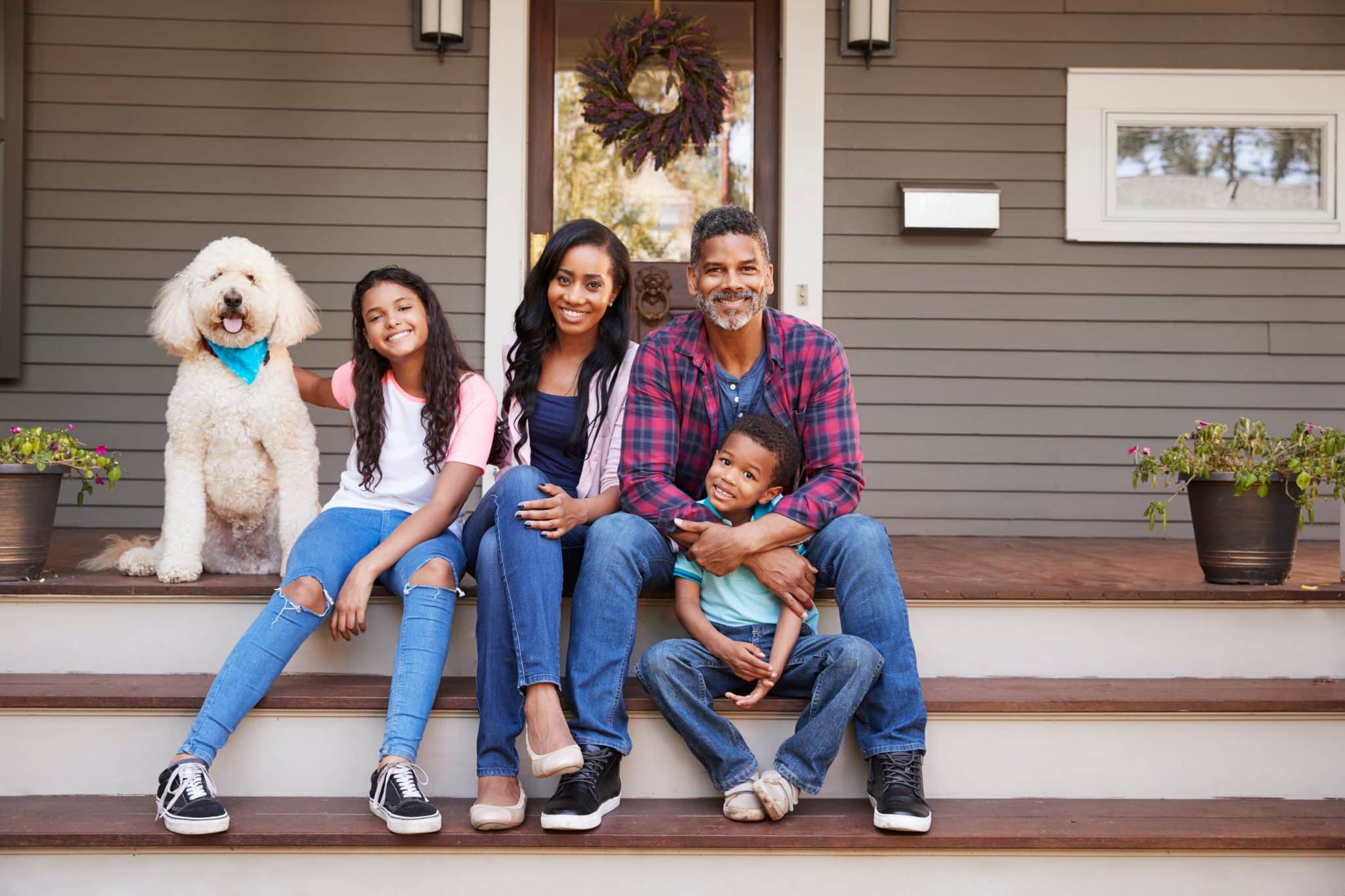 Family With Children And Pet Dog Sit On Steps Of Home in New York Family With Children And Pet Dog Sit On Steps Of Home in New York