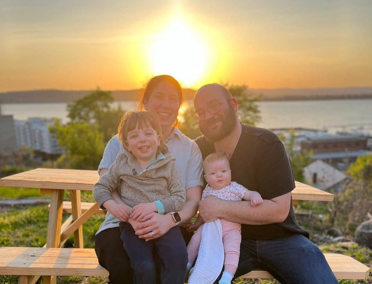 The Young family with scenic views of the Hudson River behind Riverworks. The Young family with scenic views of the Hudson River behind Riverworks.