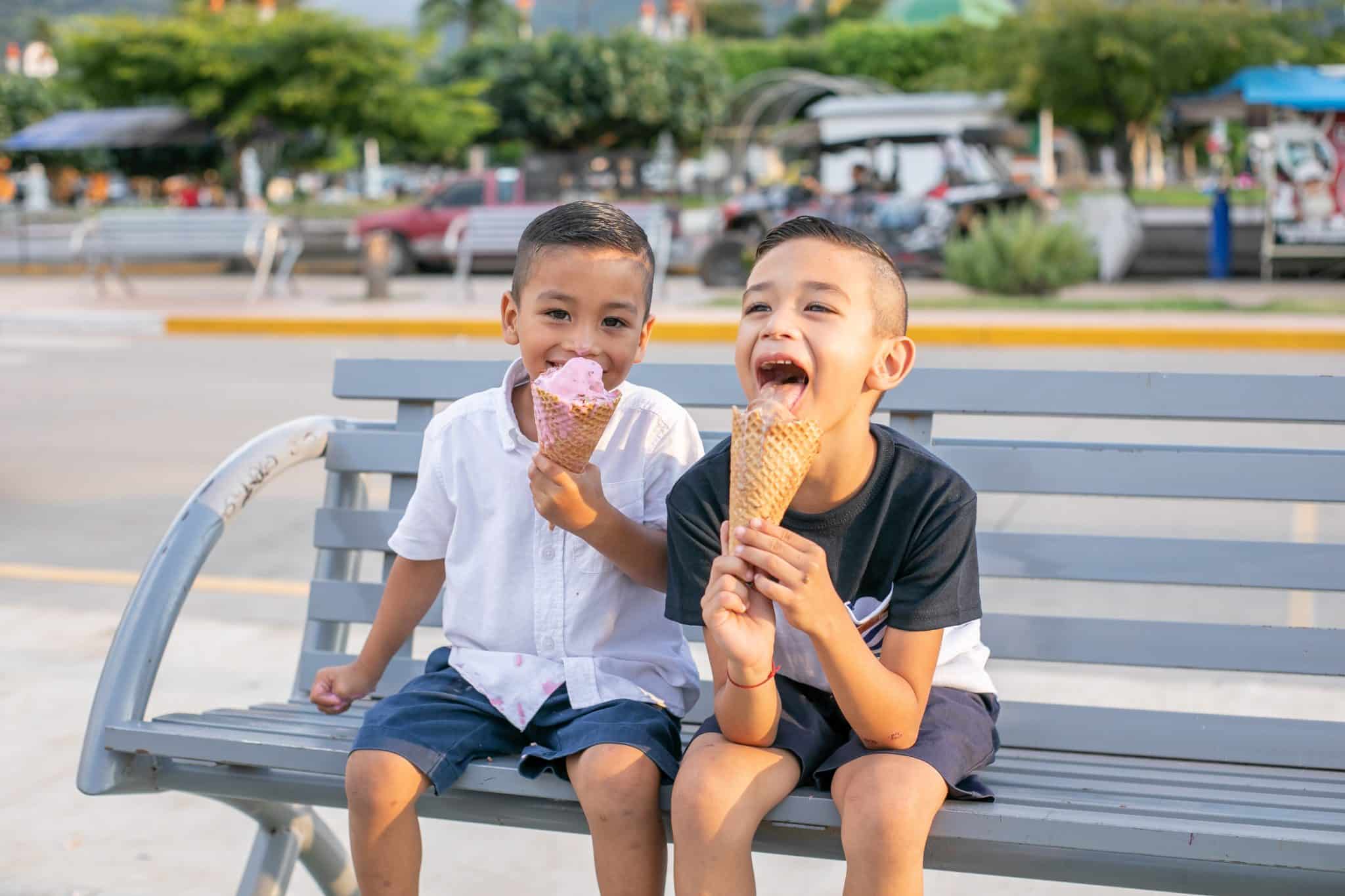 Kids enjoying ice cream on a park bench Kids enjoying ice cream on a park bench
