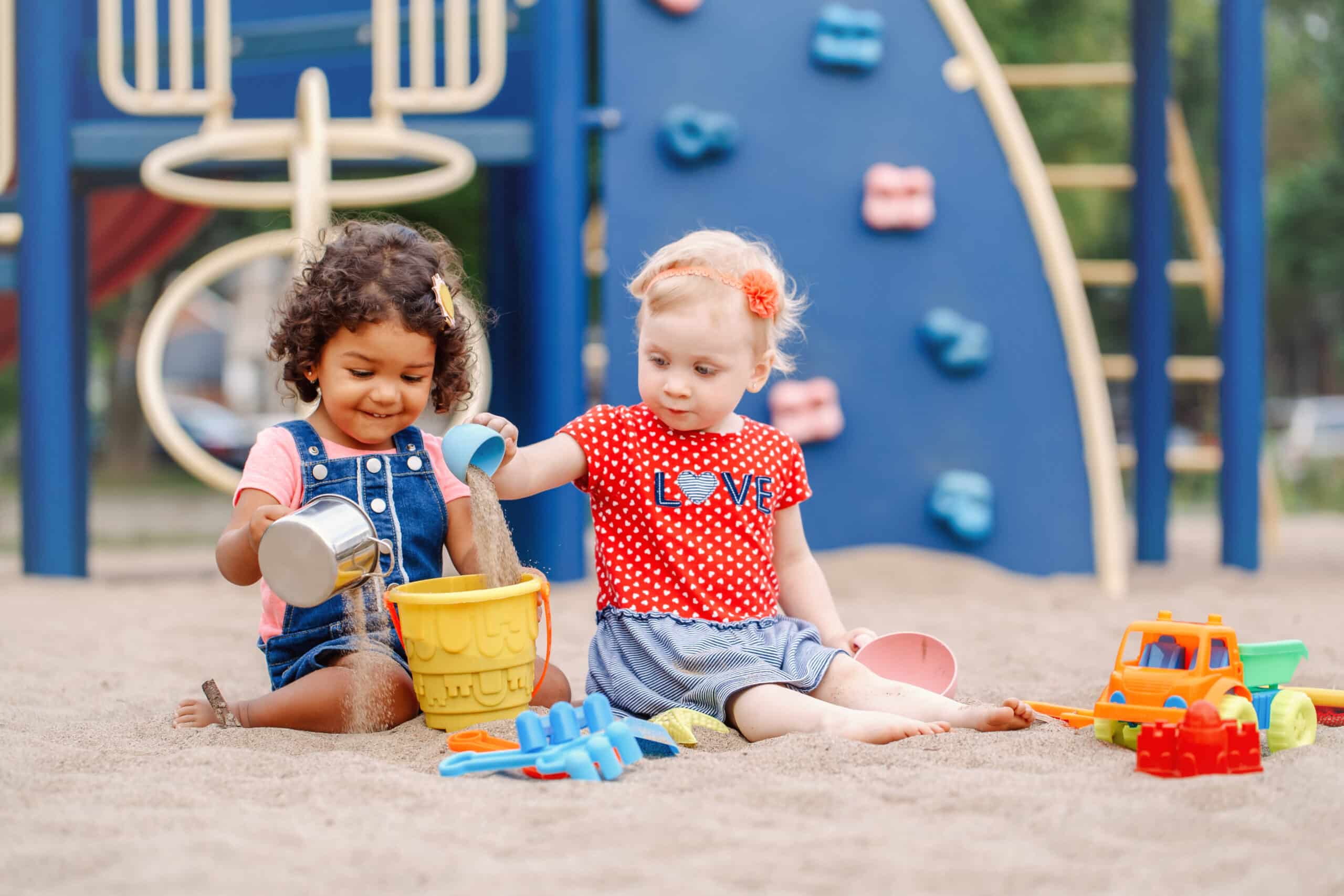 Little kids playing in the sand at a playground
