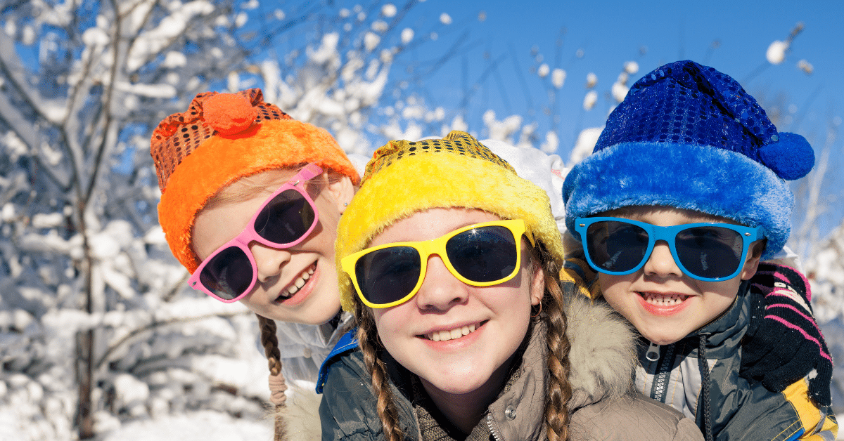 Winter Life for Families: City vs. Suburbs Children bundled up in winter hats and coats playing outside in the snow, illustrating suburban winter life for families